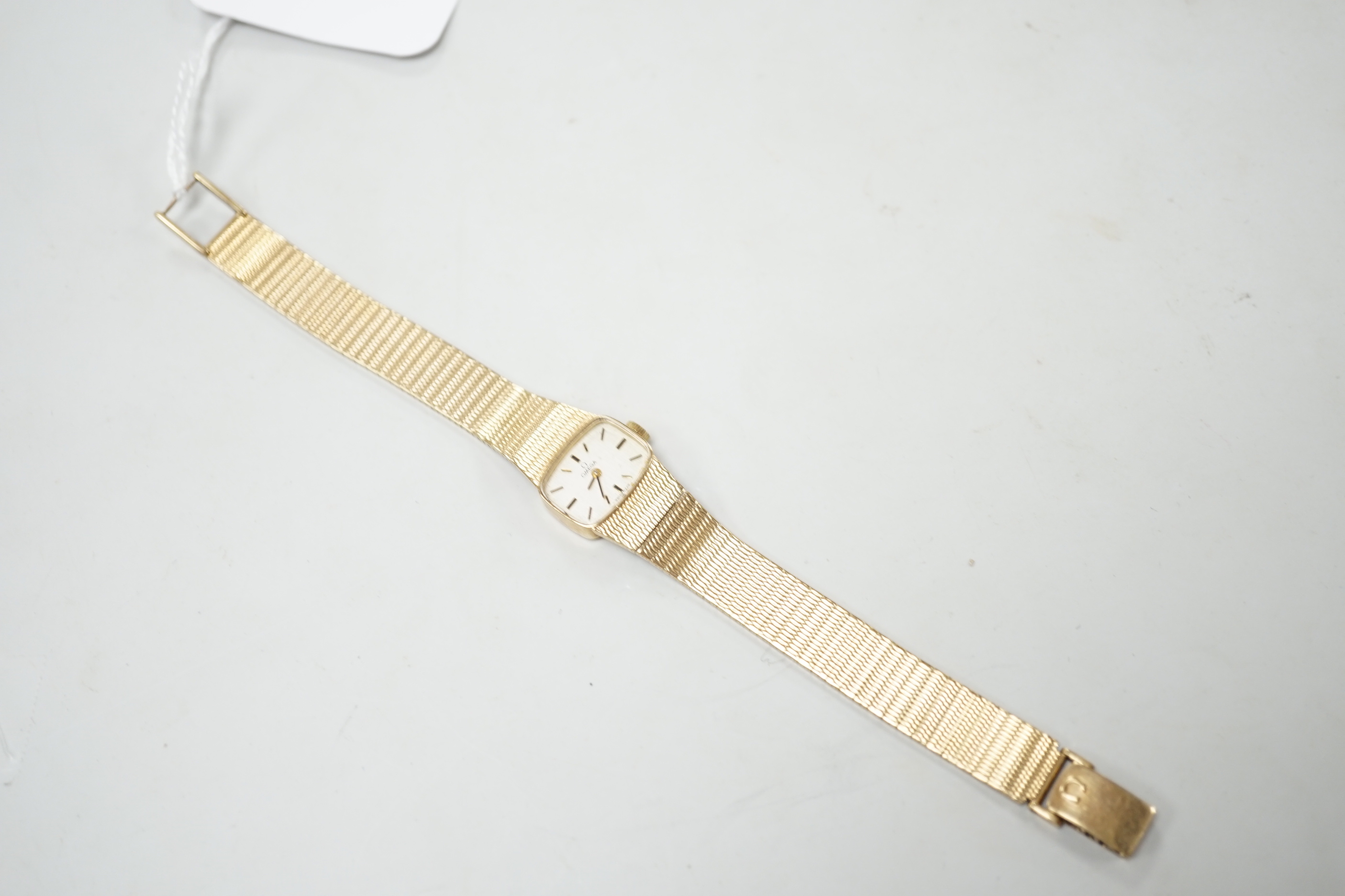 A lady's Omega 9ct gold manual wind wrist watch, with integral 9ct gold bracelet, gross weight 31.3 grams.